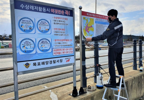 목포해경이 해양레저활동 허가대상 수역 공고판을 점검하고 있다. (사진제공 = 목포해양경찰서)